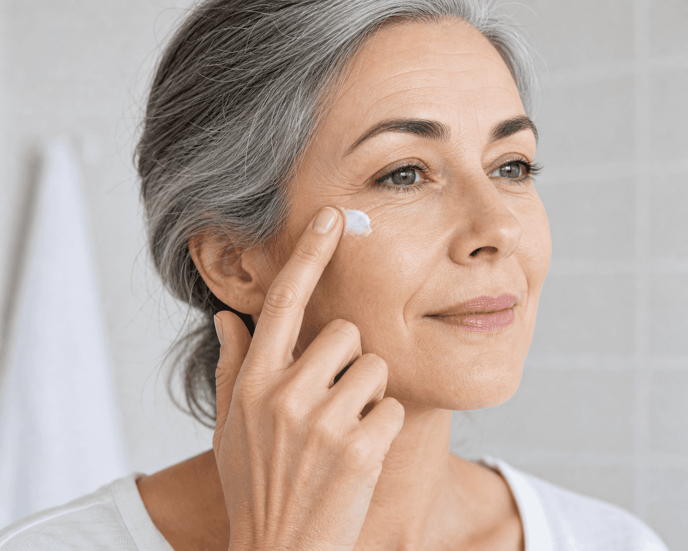 Woman applying anti-aging cream to her face