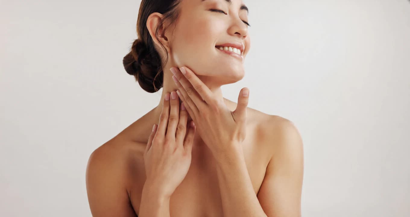 Smiling woman touching her neck after a skincare routine